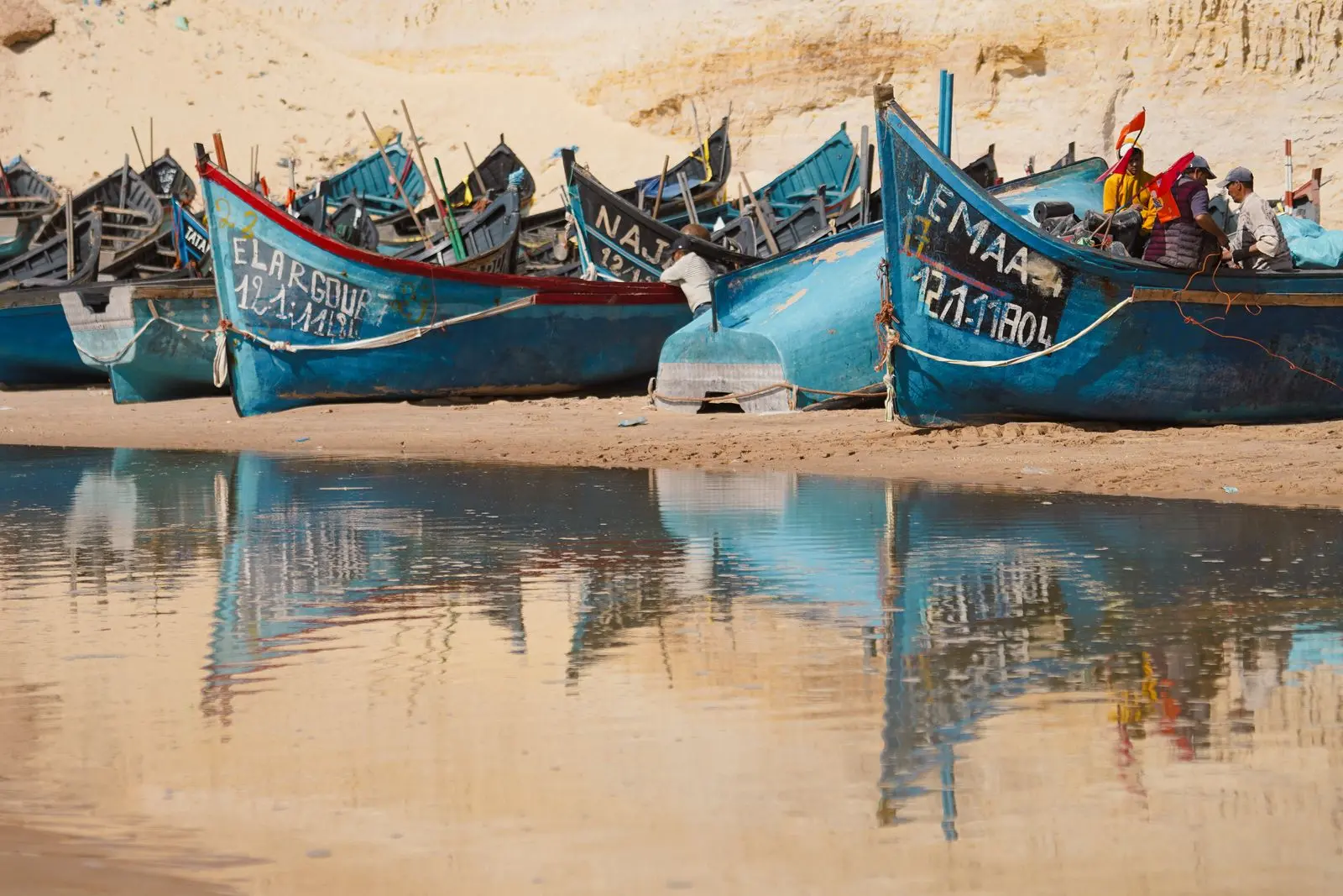 Barques de pêche bleues échouées sur une plage de Dakhla